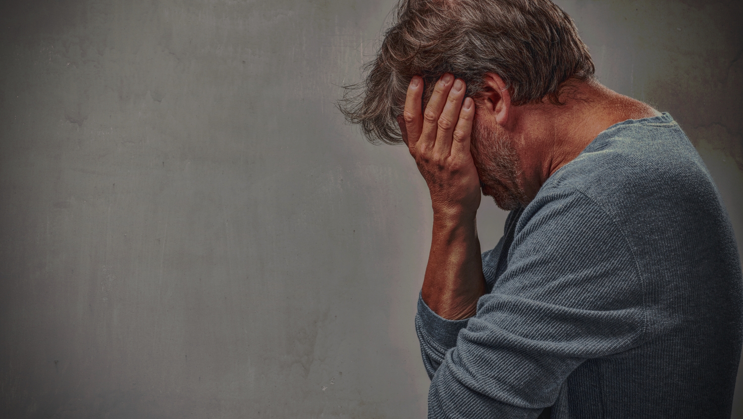 Depressed rejected man portrait over gray wall background